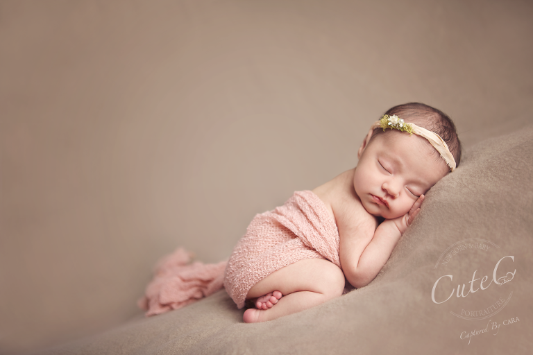 sleeping newborn girl in pink wrap